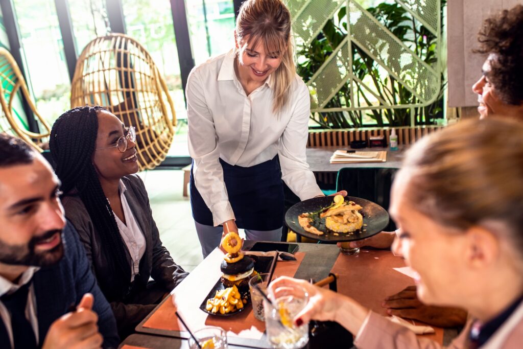 smiling waitress serving meal to group of business 2025 02 11 14 58 54 utc